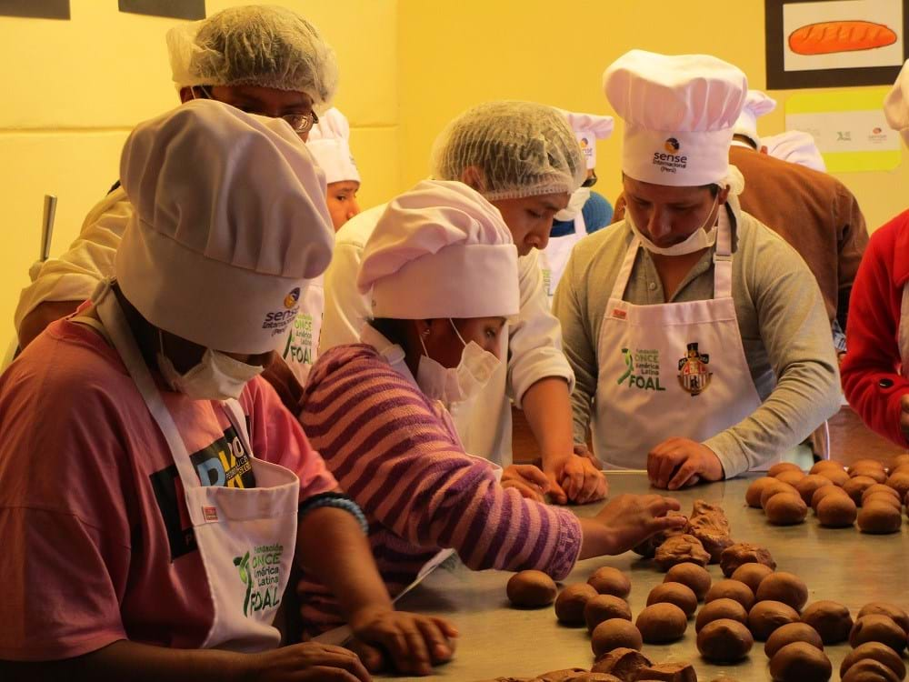 A group of young people in chef's hats cooking