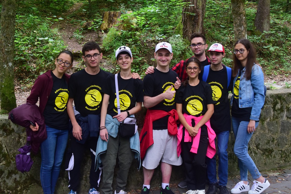 A group of young people standing in a forest.