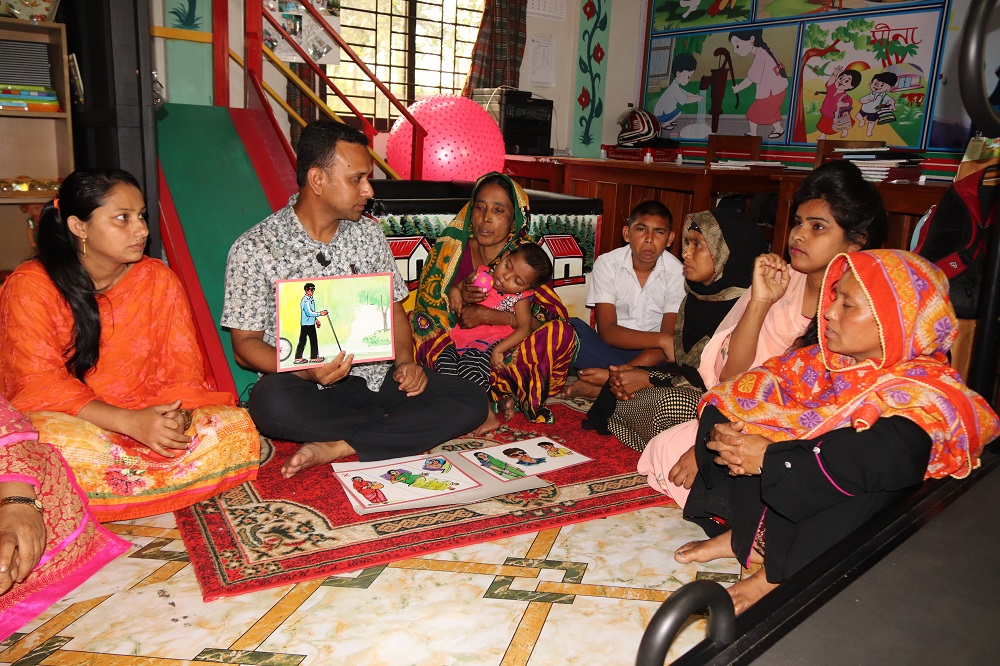 A group of women and children reading with a teacher