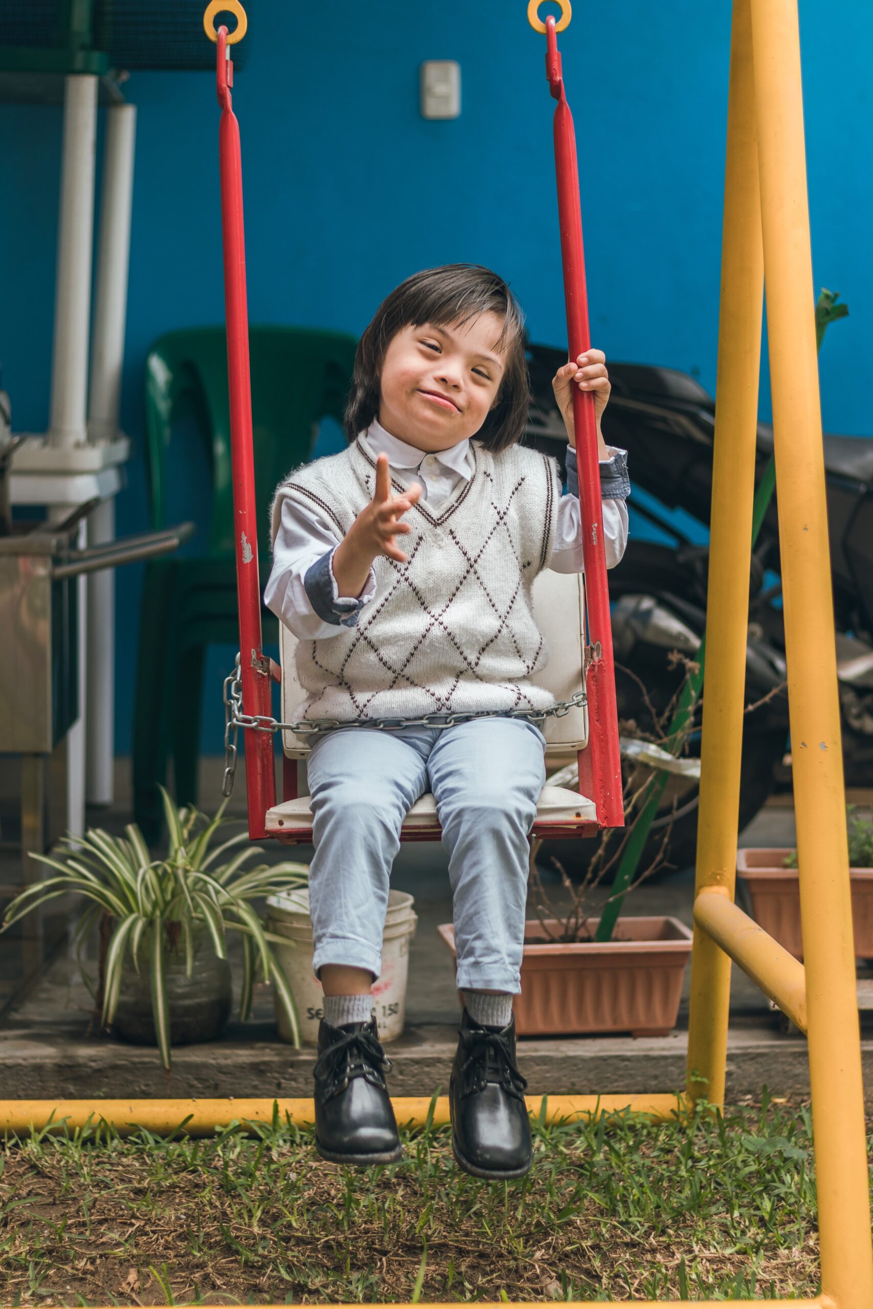 A young boy sitting on a swing