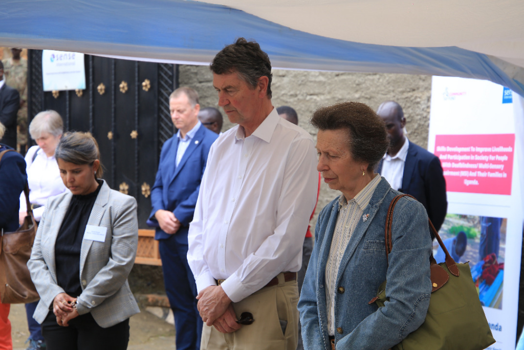 A group of people with their heads bowed, HRH Princess Anne in the foreground