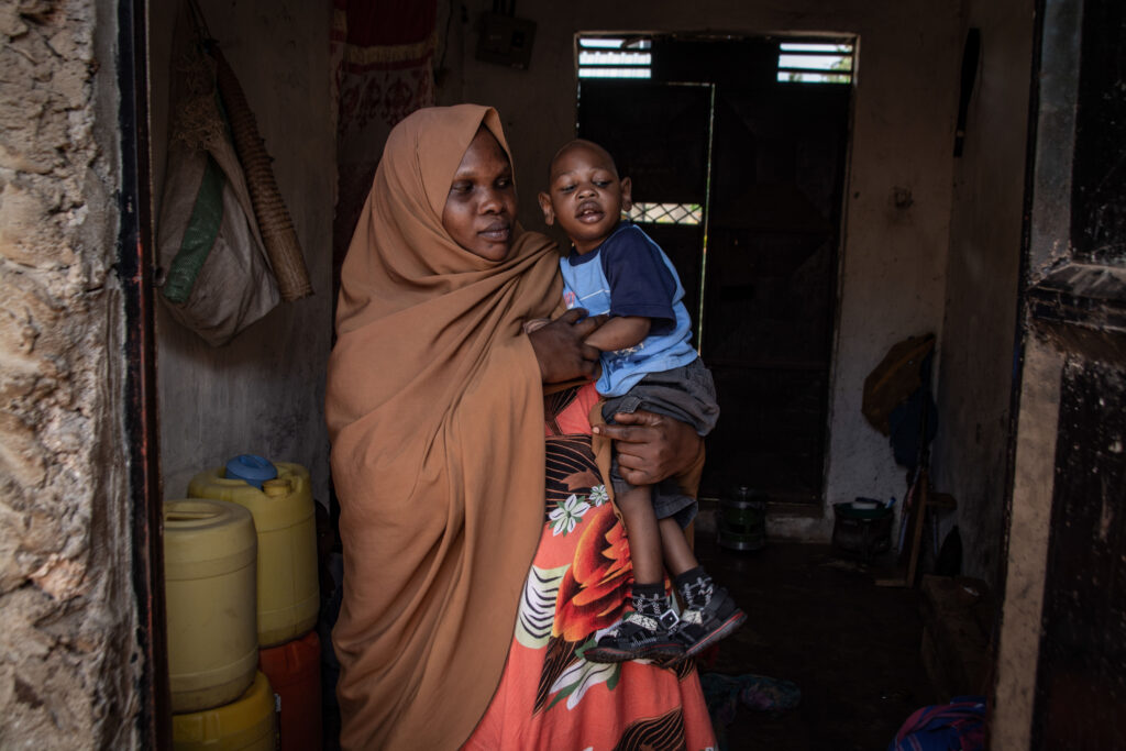 A woman standing up and holding a young boy