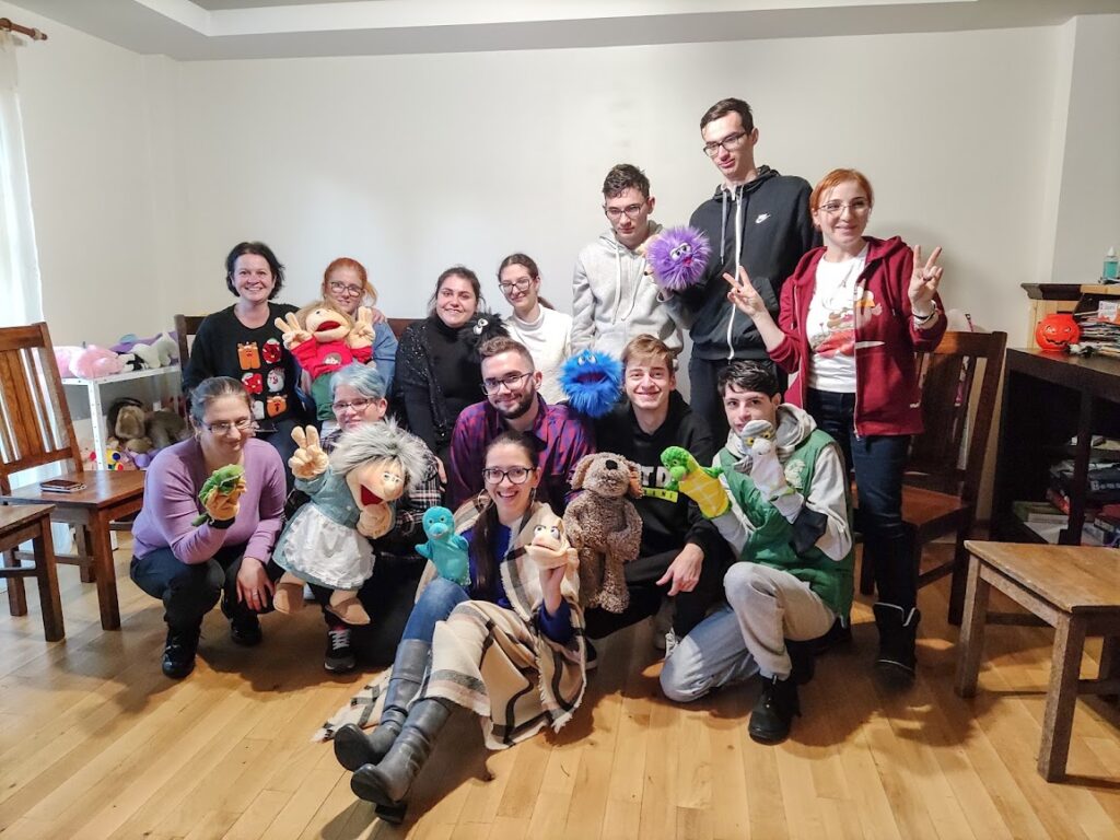 A group of young people with hand puppets.