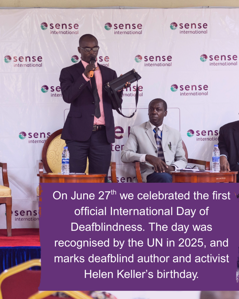 Two adult Kenyan men wearing suits speak on a stage decorated with the Sense International logo. Text reads: On June 27th we celebrated the first official International Day of Deafblindness. The day was recognised by the UN in 2025, and marks deafblind author and activist Helen Keller’s birthday.