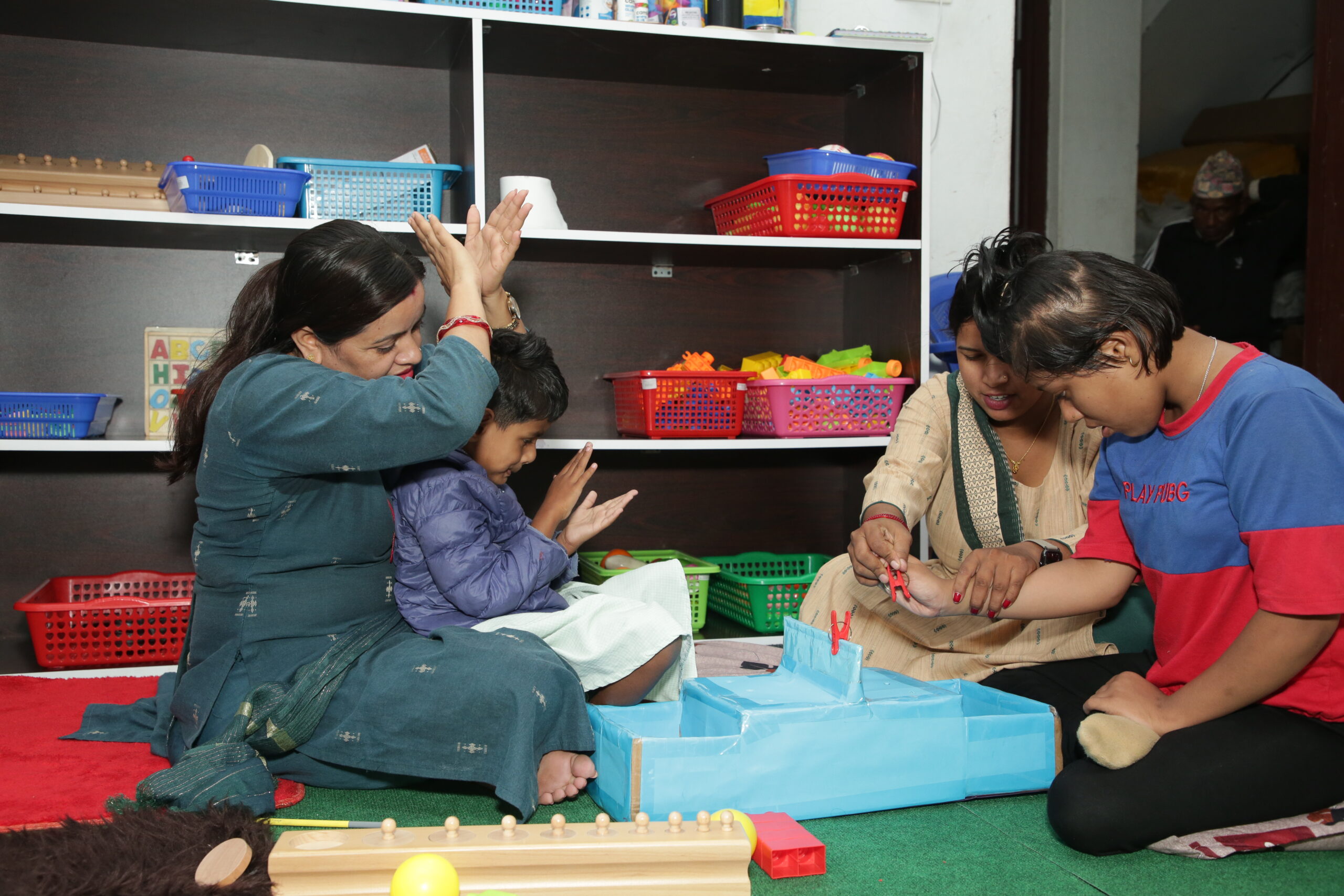 Nepali adults and young children play with colourful sensory toys