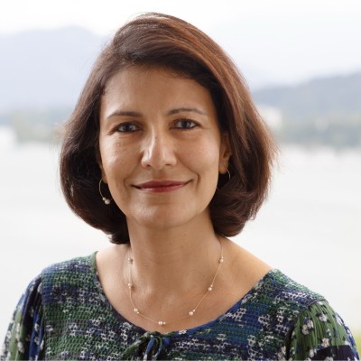 Headshot of a South Asian woman with short dark hair wearing a green top